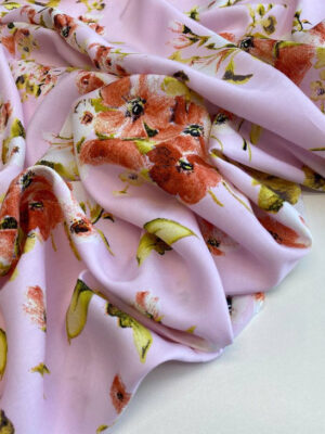 Штапель Італія з рідко розташованими квітами і зеленкуватим листям на ніжно-рожевому фоні