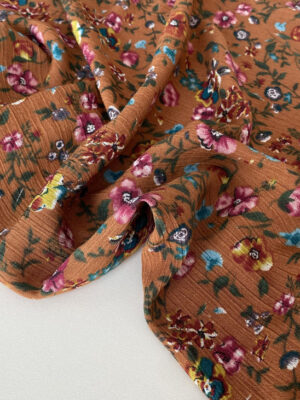 Віскоза жата з мілкими квітами на коричнево-рижому фоні