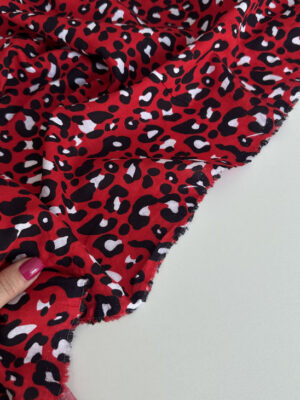 Батистова тканина жата чорно-білі ляпки типу лео на червоному фоні