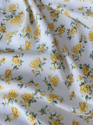 Штапель білого кольору с жовтими квітами і зеленими листочками