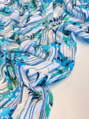 Віскозний крепдешин Італія з бірюзово-синім листям і смужками на білому фоні у стилі Зіммерман