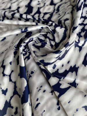 Атлас на основі з темно-синім абстракційним дизайном на молочно-срібному фоні