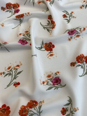 Суперсофт з рідко розташованими теракотово-червоними квітами і зеленкуватим листям на молочному фоні