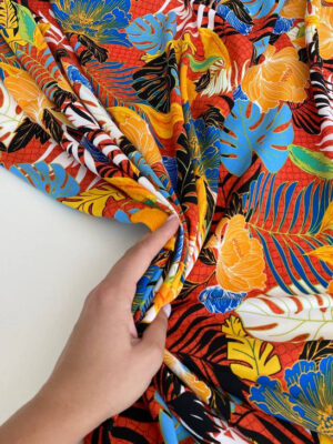 Платтяна тканина для бренду Гарри Вебер з яскравими жовтими, блакитними і помаранчевими листями на чорному