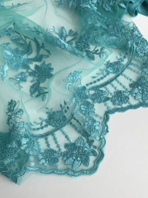 Мереживне полотно акватичного кольору з фактурним вишитим принтом та фігурними фестонними краями