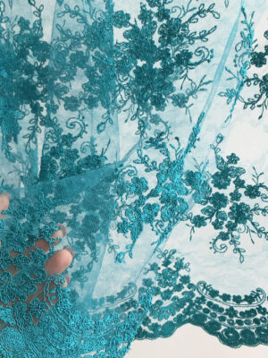 Мереживне полотно бірюзового кольору з фактурним вишитим принтом та фігурними фестонними краями