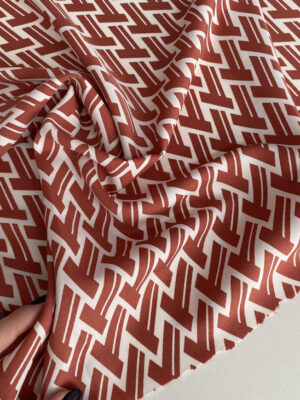 Суперсофт з графічними темно-червоними зиг-загами на біло-молочному фоні