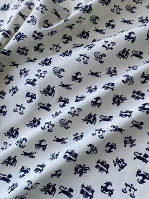 Котон молочно-ванільного кольору з темно-синіми знаками зодіаку