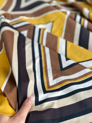 Полірований поплін-батист з яскравою графікою коричнево-жовтого з чорним кольору на світлому бежі