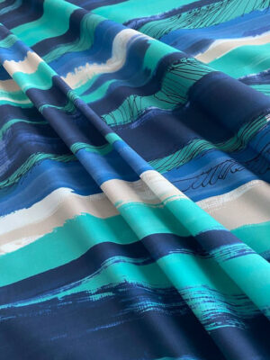 Полірований поплін-котон з бірюзово-блакитною графікою на світлому фоні з чорними розчерками