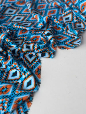 Тканина штапель з крупними помаранчевими ромбами на яскраво-бірюзовому фоні