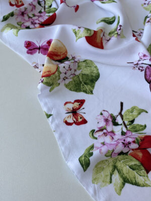 Тканина штапель  з рідко розташованими фруктами та метеликами на білому фоні