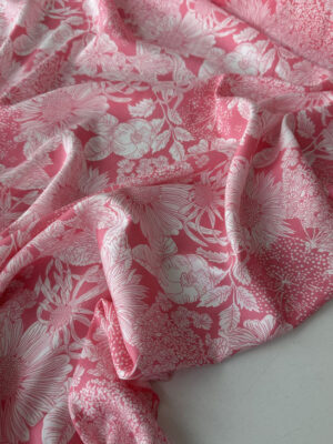 Штапель з білими мереживними квітами типу соняхів на ніжно-рожевому фоні